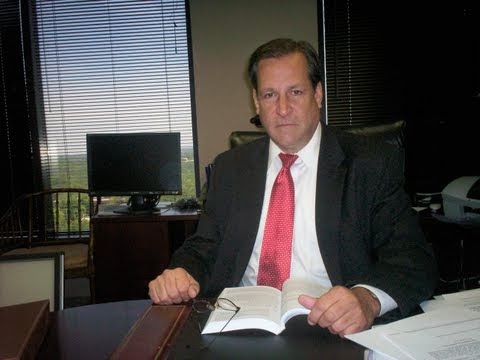 This is a photo of Theodore N. Stapleton, P.C. sitting at his desk in his office, located at 2802 Paces Ferry Road. Suite 100-B. Atlanta, Georgia, 30339.